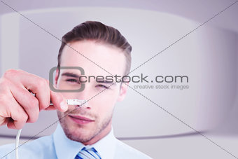 Composite image of concentrated businessman holding a cable