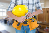 Composite image of technician holding hammer and hard hat