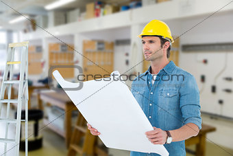 Composite image of architect holding blueprint in house