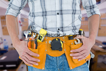 Composite image of cropped image of technician with tool belt around waist