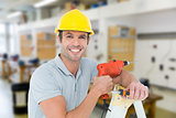 Composite image of happy technician holding drill machine while leaning on ladder