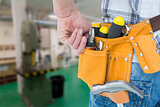 Composite image of technician with tool belt around waist