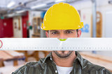 Composite image of handyman looking at spirit level
