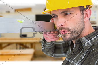 Composite image of carpenter using spirit level