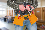 Composite image of manual worker holding gloves and hammer power drill