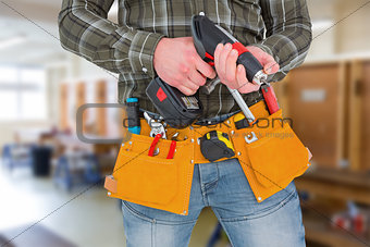 Composite image of manual worker holding gloves and hammer power drill