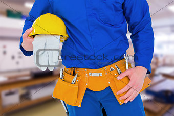 Composite image of handyman holding helmet