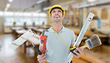 Composite image of worker holding various equipment over white background