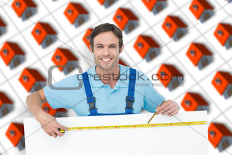 Composite image of happy carpenter measuring blank bill board