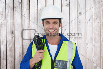 Composite image of confident electrician with wire against white background