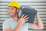 Composite image of handyman carrying toolbox on shoulder