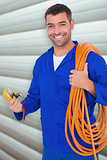 Composite image of smiling electrician with wire roll and multimeter