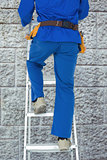 Composite image of low section of carpenter climbing step ladder