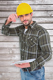 Composite image of smiling handyman writing on clipboard