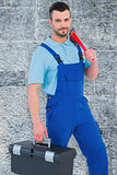 Composite image of repairman with toolbox and monkey wrench