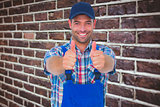 Composite image of portrait of happy male repairman gesturing thumbs up