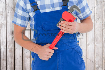 Composite image of repairman holding adjustable pliers