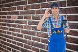 Composite image of plumber holding plunger while gesturing ok sign
