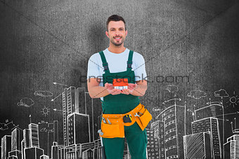 Composite image of happy construction worker holding house model