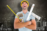 Composite image of laughing manual worker holding various tools
