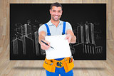 Composite image of smiling handyman giving clipboard for signature