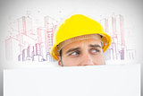 Composite image of repairman looking away while in front of billboard