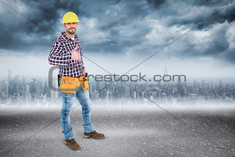 Composite image of smiling handyman gesturing thumbs up
