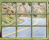 travel concept - windy road through old window