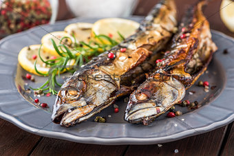Baked Mackerel Fish with Herbs and Lemon on a Plate