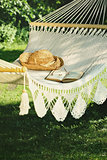 Crocheted hammock with straw hat and book