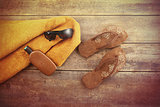 Orange towel and beach items on wood