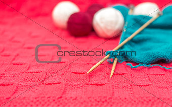 yarn balls and spokes on knitted fabric close-up