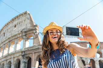 Woman tourist taking selfie at Colosseum in Rome in summer