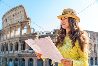 Smiling woman holding map of Rome at Colosseum in Rome