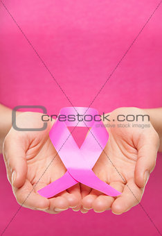 Woman holding a pink cancer awareness ribbon