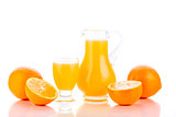 Orange juice in pitcher and oranges 