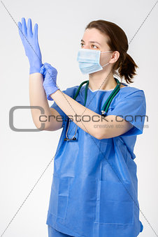 Doctor putting on blue surgical gloves