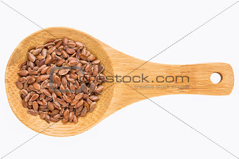 brown flax seeds on wooden spoon