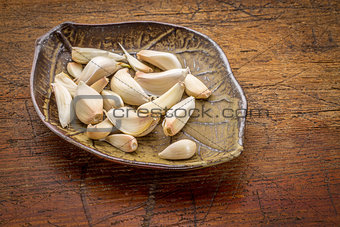 garlic cloves on a leaf bowl