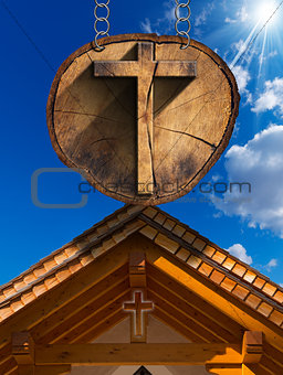 Cross on Tree Trunk with Wooden Church