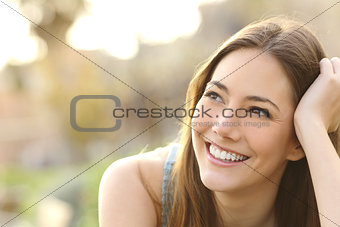Woman with white teeth thinking and looking sideways