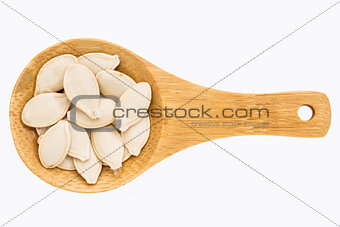 pumpkin seeds on wooden spoon