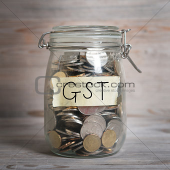 Coins in money jar with gst labe