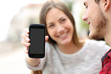 Couple showing apps in a blank smart phone screen