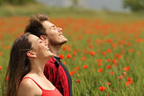 Happy couple breathing fresh air in a red field