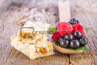 muesli bars with fresh berries in spoon on wooden