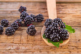 blackberries with spoon on wooden background