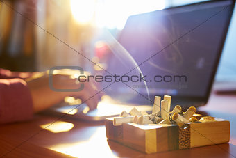 Man Using Laptop And Smoking Cigarette In The Morning