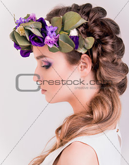 Side view of a girl with flower crown posing in studio