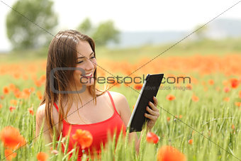 Woman reading ebook in a red field